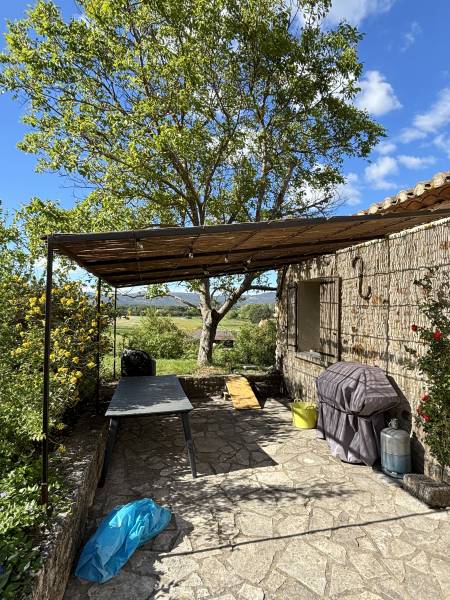 Pergola adossée à la façade avec des canisses