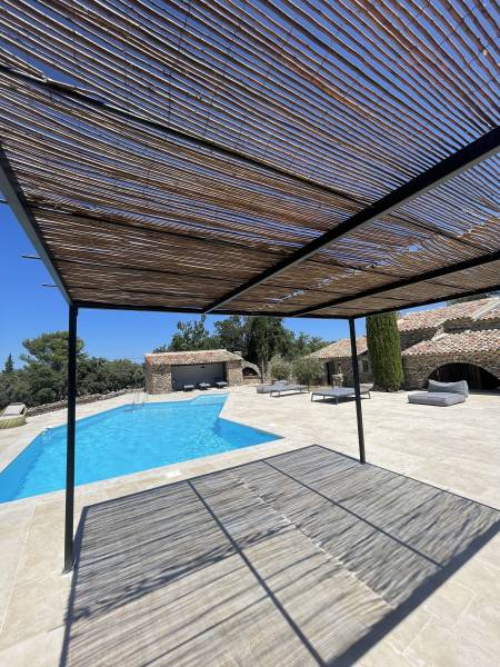 Fabrication et pose d'une pergola en fer forgé pour la piscine, avec des canisses, réalisée par notre équipe de ferronniers d'art près d'Apt dans le Luberon (84)